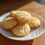 A stack of golden 3-ingredient butter cookies with fork marks on a white plate.