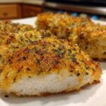 Close-up of a perfectly cooked, golden-brown baked ranch chicken cutlet showing the juicy white interior.