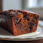 Close-up of a slice of moist chocolate chip banana bread recipe, showing melted chocolate chunks inside.