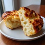 Close-up of homemade English muffins split open revealing the signature nooks and crannies texture.