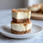 Two stacked no-bake mini cheesecake bites showing creamy filling and crumbly graham cracker crust.