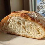Close-up of the open crumb structure of a freshly baked sourdough sandwich bread loaf.