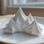 White, stiff peaks of royal icing, resembling snow-capped mountains, perfect for gingerbread house icing.