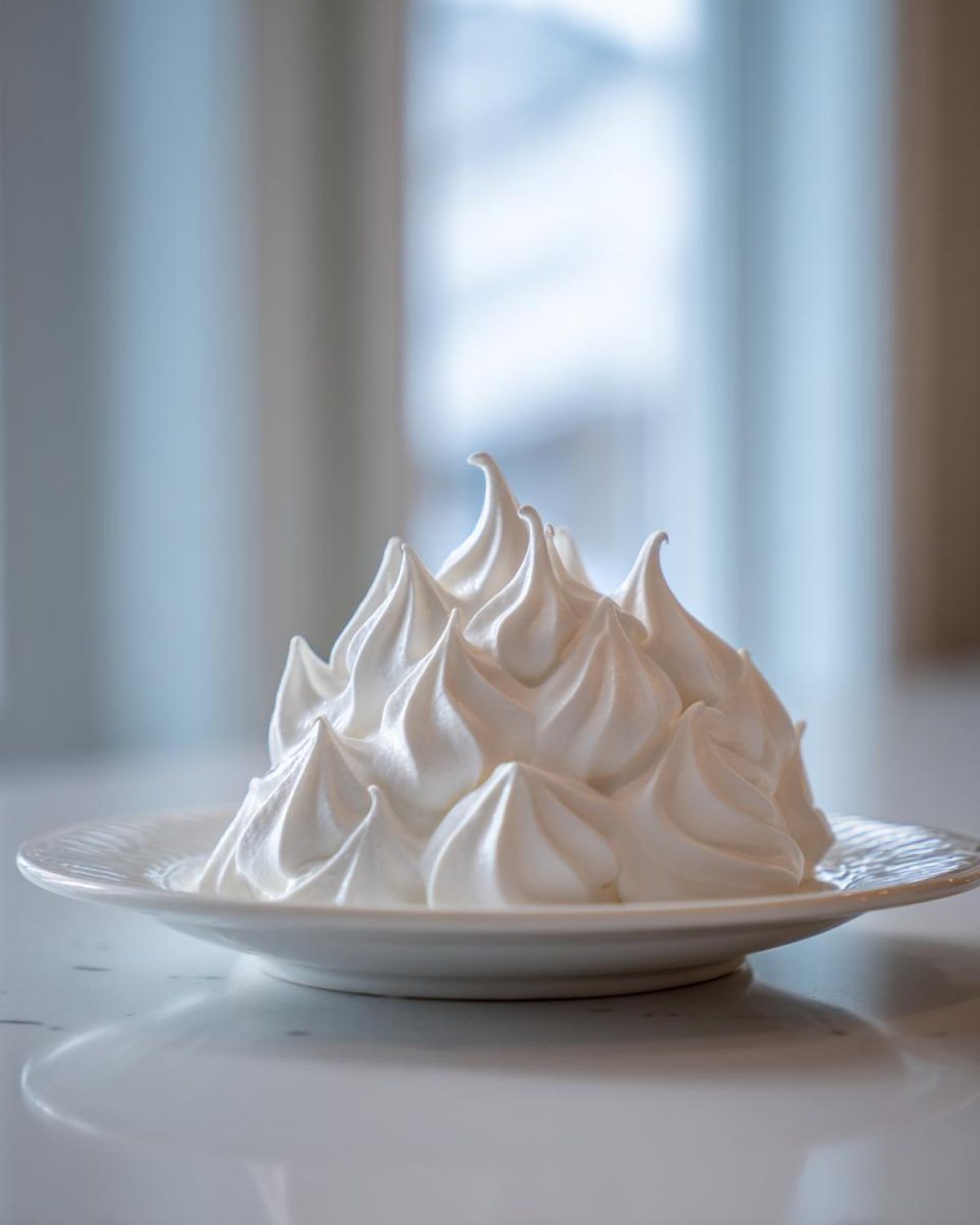 A mound of stiff, bright white royal icing piped into sharp peaks, perfect for gingerbread house icing.