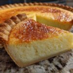A close-up of a slice of creamy buttermilk pie showing the golden caramelized top and flaky crust.