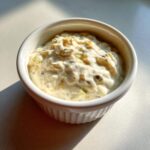 Close-up of creamy homemade tartar sauce recipe with visible relish and capers in a small white bowl.