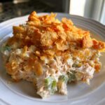 A scoop of creamy hot chicken salad mixed with celery, topped generously with golden, crunchy cornflakes.