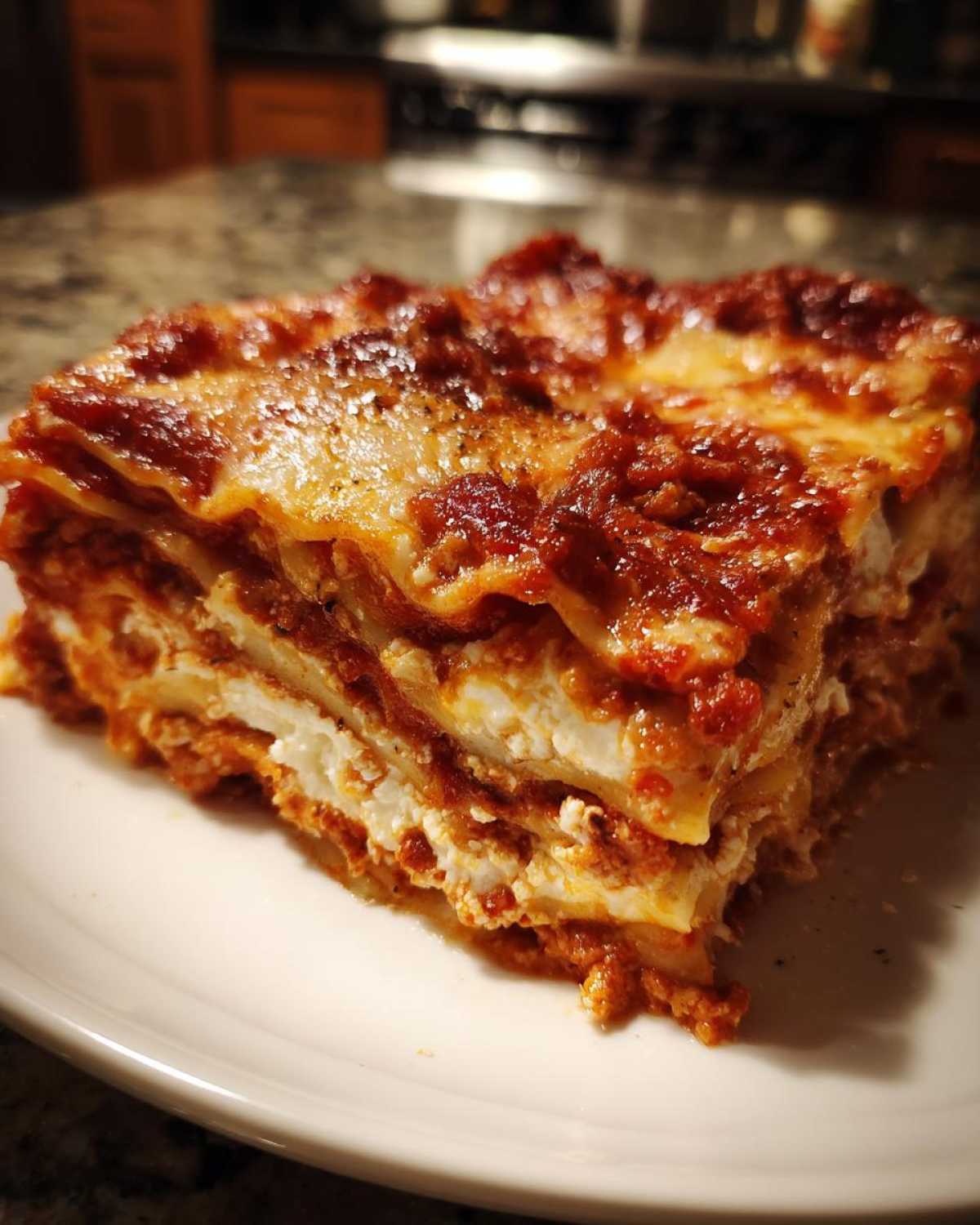 A thick, layered slice of Lasagna with Cottage Cheese served on a white plate.