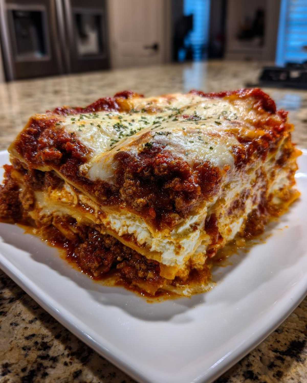 A thick, layered slice of lasagna with cottage cheese, meat sauce, and melted mozzarella topping.