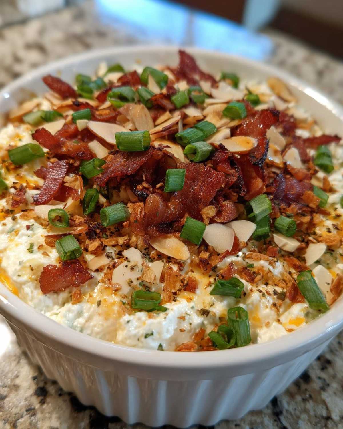 Close-up of the amazing Neiman Marcus dip topped with bacon, almonds, and green onions.
