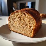 Close-up of the soft, porous crumb texture of a freshly baked whole wheat bread loaf.