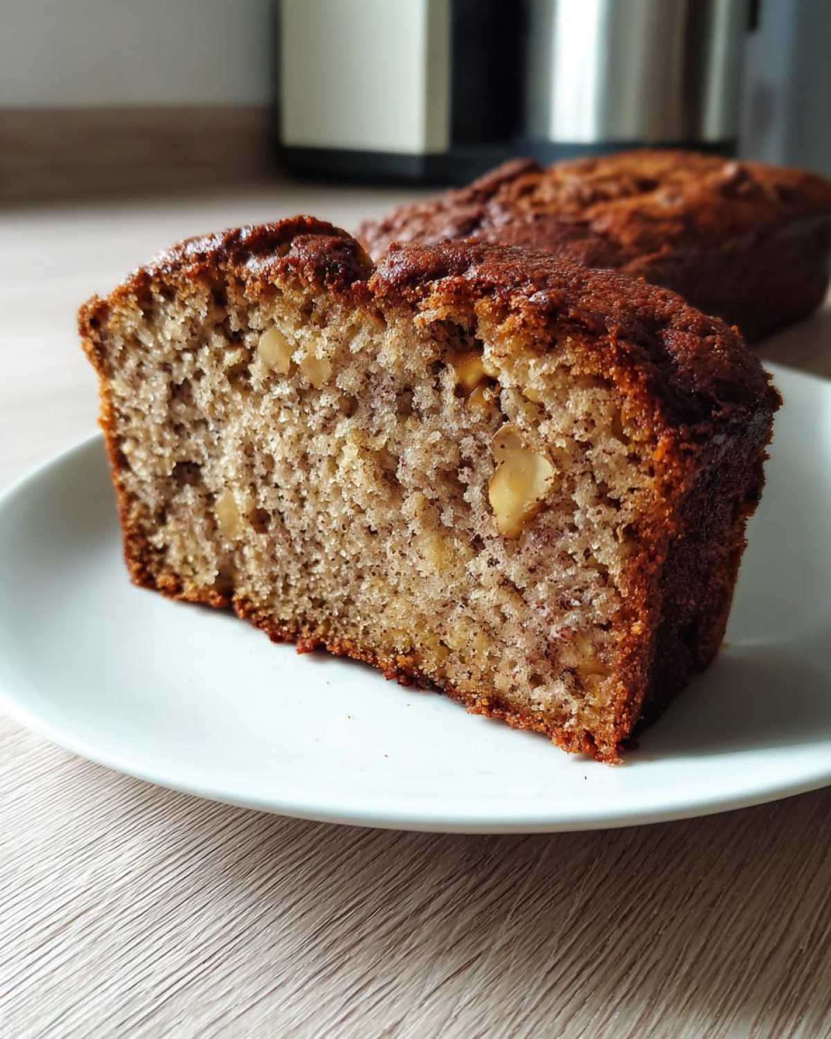 Close-up of a moist slice of sugar free banana bread showing walnuts in the crumb.