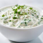 Close-up of creamy 5-Minute Greek Yogurt Ranch Dip topped with fresh chopped parsley.