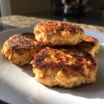A stack of four perfectly cooked Air Fryer Salmon Patties with a golden-brown, crispy exterior.