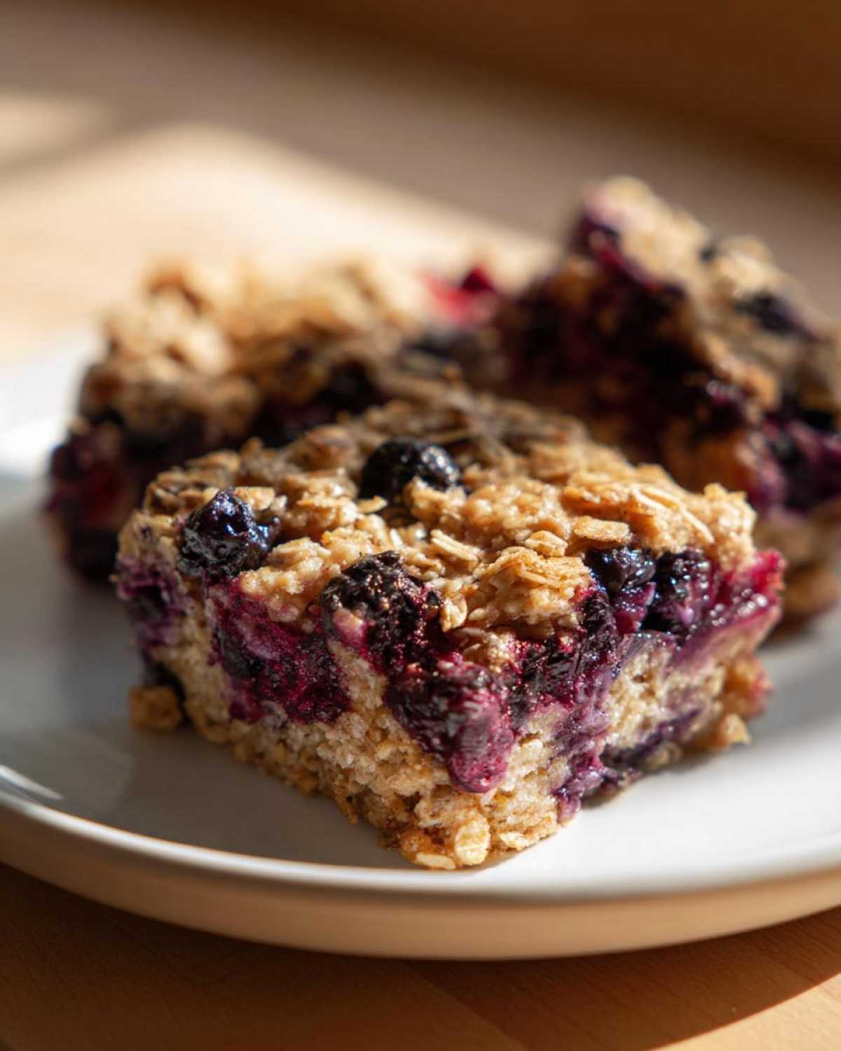 Close-up of a moist square of Blueberry Baked Oatmeal Squares showing oats and burst blueberries.