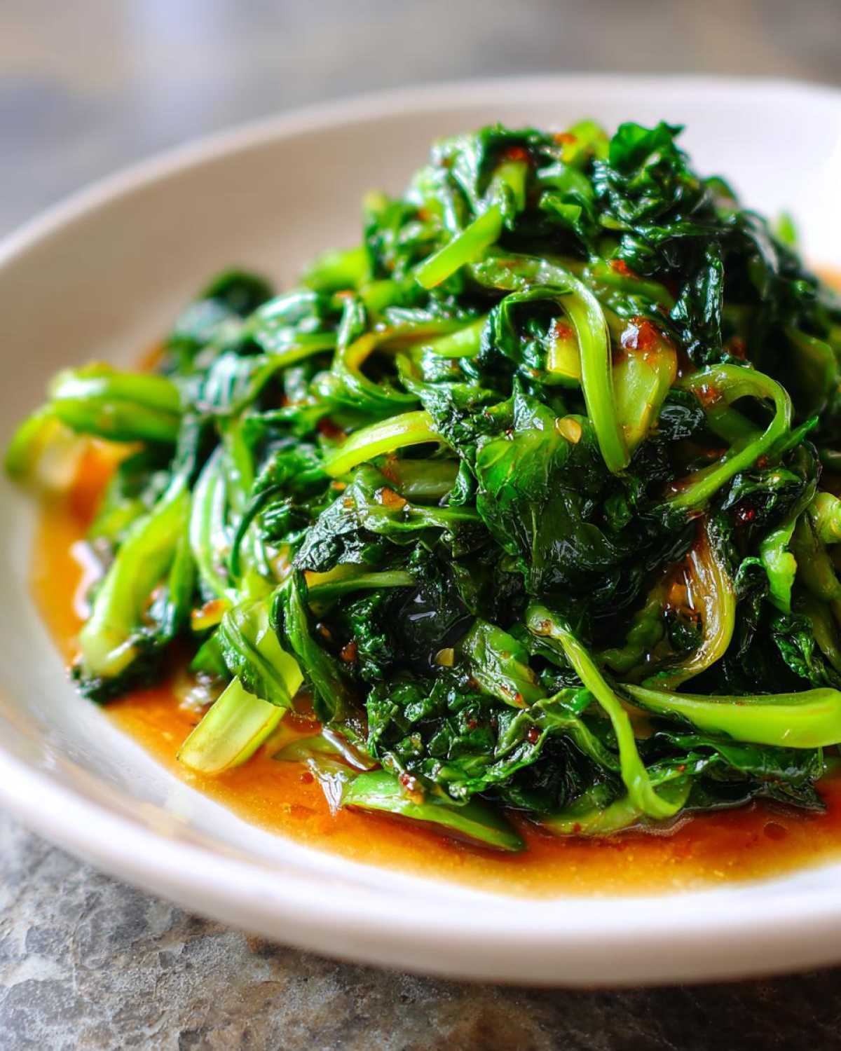 Close-up of vibrant green Cabbage Stir Fry with Garlic Ginger Sauce glistening in a savory brown sauce.