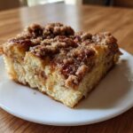 A close-up of a square slice of Cinnamon Roll Overnight French Toast Bake with gooey cinnamon topping.