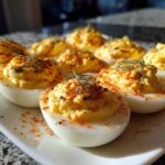 A plate of Classic Deviled Eggs with Dill Pickle Relish, garnished with paprika and fresh dill sprigs.