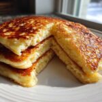 A stack of three thick, fluffy Gluten-Free Buttermilk Pancakes, cut to show the texture, sitting on a white plate.