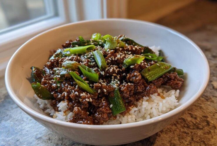 A close-up of Korean Ground Beef Bulgogi Bowls featuring savory ground beef over white rice, topped with green onions and sesame seeds.
