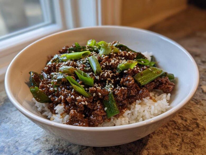 A close-up of Korean Ground Beef Bulgogi Bowls featuring savory ground beef over white rice, topped with green onions and sesame seeds.