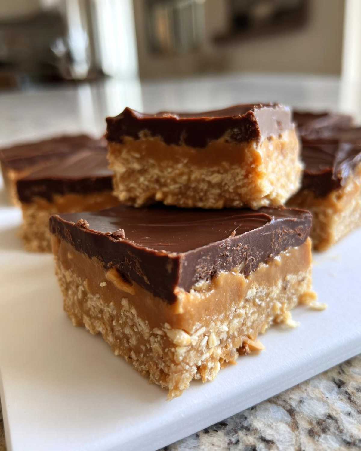 Close-up of layered No-Bake Chocolate Peanut Butter Oat Bars showing oat base, peanut butter layer, and chocolate topping.