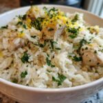 Close-up of One-Pot Chicken and Rice with Lemon and Herbs, topped with fresh parsley and lemon zest.