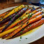 Close-up of glossy Sheet Pan Roasted Rainbow Carrots with Honey, garnished with parsley.