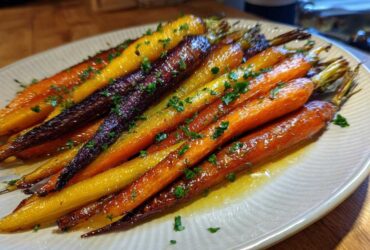 Close-up of glossy Sheet Pan Roasted Rainbow Carrots with Honey, garnished with parsley.