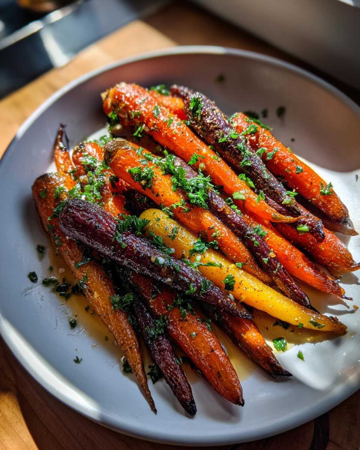 A plate of beautifully roasted Sheet Pan Roasted Rainbow Carrots with Honey, garnished with fresh parsley.