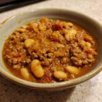 Close-up of a hearty bowl of Spicy Turkey White Bean Chili with ground turkey and large white beans.