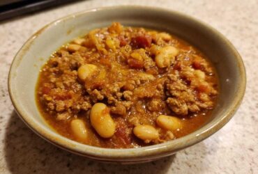 Close-up of a hearty bowl of Spicy Turkey White Bean Chili with ground turkey and large white beans.