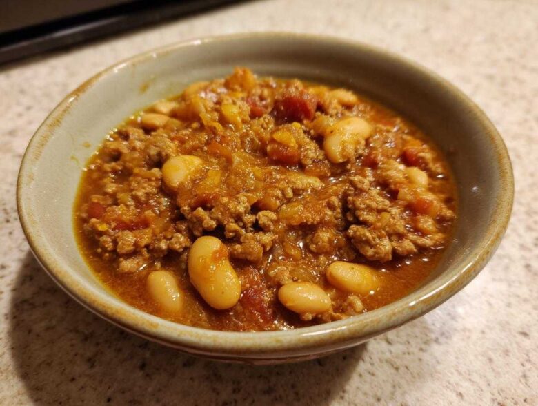 Close-up of a hearty bowl of Spicy Turkey White Bean Chili with ground turkey and large white beans.