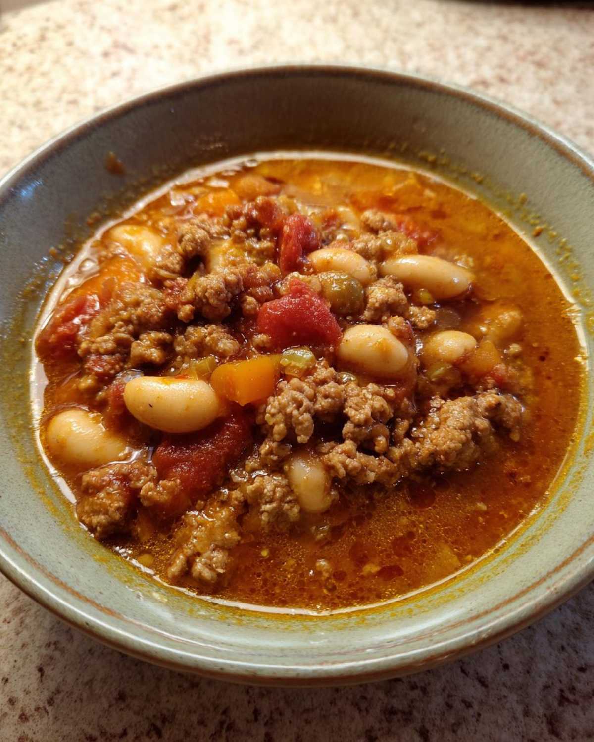 Close-up of a hearty bowl of Spicy Turkey White Bean Chili, featuring ground turkey, white beans, and tomatoes in a rich broth.