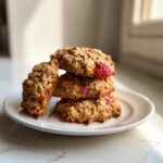 A stack of four delicious Strawberry Oatmeal Breakfast Cookies featuring visible chunks of bright red strawberries.