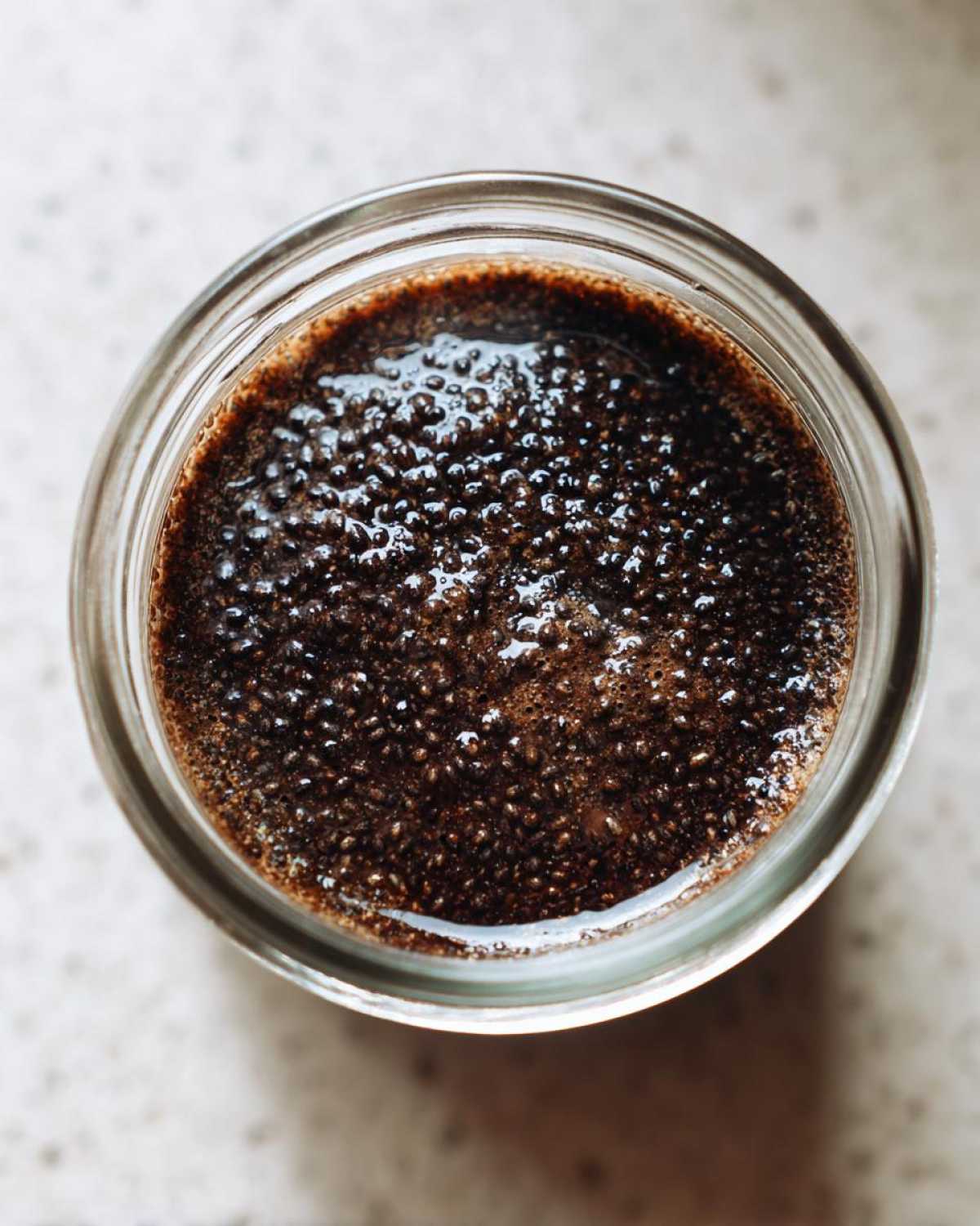 Overhead view of rich, dark Vegan Chocolate Chia Pudding showing the texture of hydrated chia seeds.