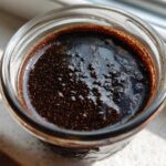 Overhead close-up view of dark, rich Vegan Chocolate Chia Pudding texture in a glass jar.