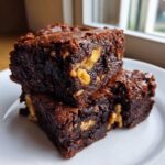 Two fudgy Banana Bread Brownies with Walnuts stacked on a white plate, ready for snack time.