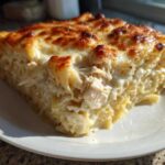 A generous slice of Cheesy Chicken Alfredo Bake with Mozzarella featuring creamy sauce and golden-brown topping.