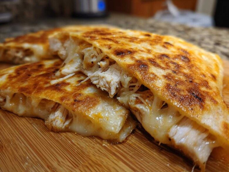 Close-up of a Cheesy Chicken Quesadilla with Crispy Tortilla, showing melted cheese stretching between shredded chicken filling.