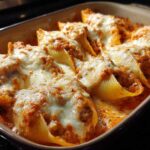Close-up of baked Cheesy Pasta Shells with Creamy Beef Sauce topped with melted mozzarella.
