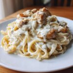 A close-up of a generous serving of Creamy Alfredo Chicken Pasta Easy Recipe on a white plate.