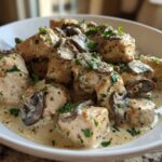 Close-up of bite-sized pieces of chicken smothered in a creamy sauce with sliced mushrooms, part of a Creamy Mushroom Chicken Skillet Easy Dinner.