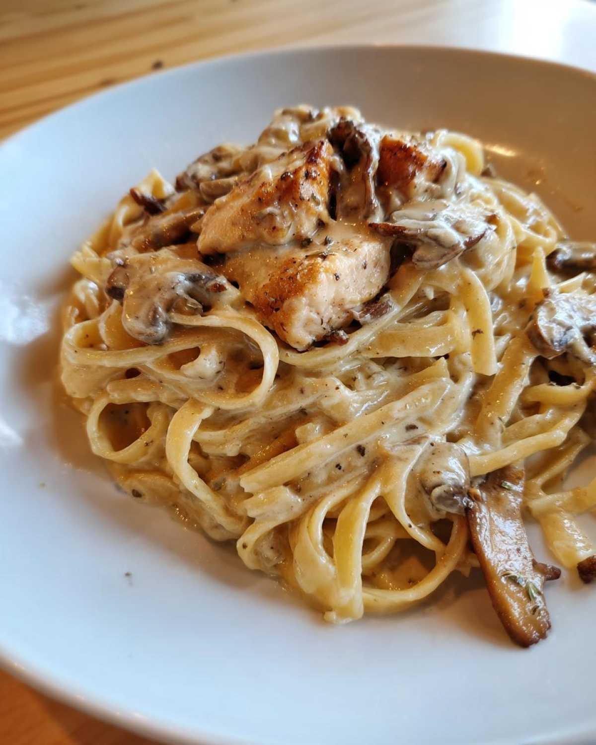 Close-up of Creamy Mushroom Garlic Pasta with Chicken tossed in a rich white sauce, served on a white plate.