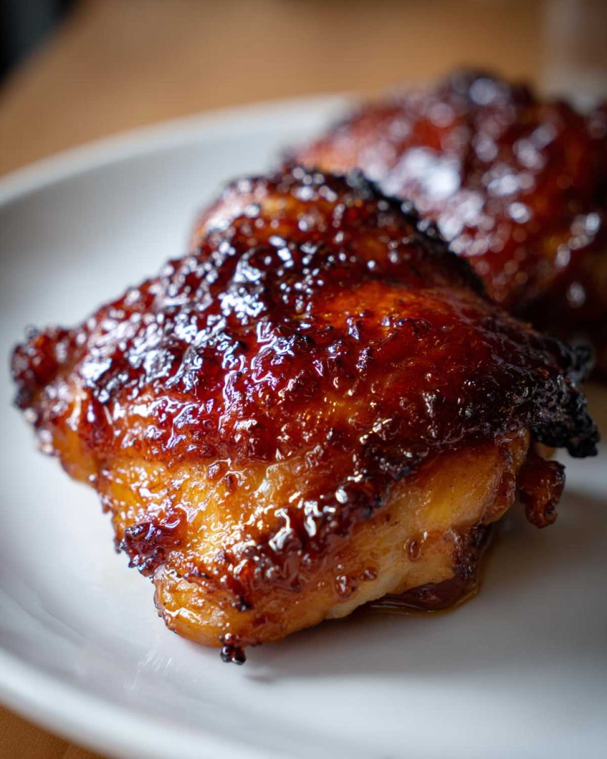 Close-up of perfectly cooked Honey Garlic Chicken Thighs with a sticky, caramelized, crispy skin.