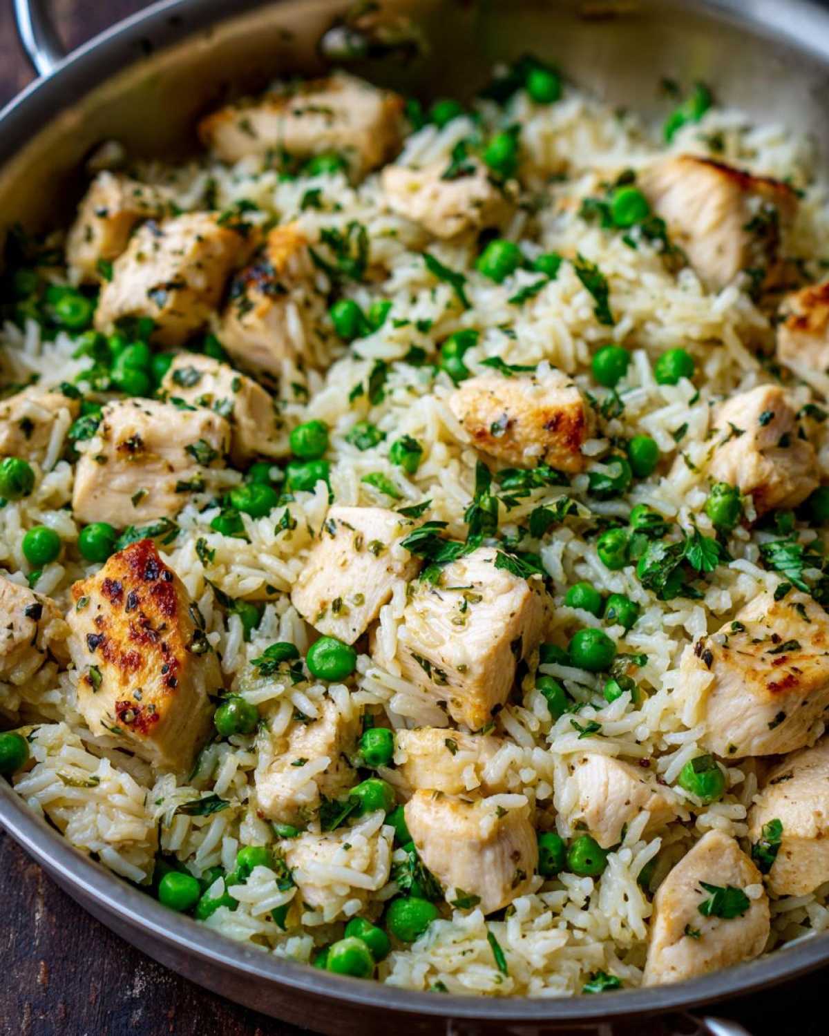 Close-up of Garlic Butter Rice with Chicken Skillet, featuring white rice, cubed chicken, and bright green peas.