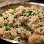 Close-up of Garlic Butter Rice with Chicken Skillet, featuring white rice, cubed chicken, and green peas.