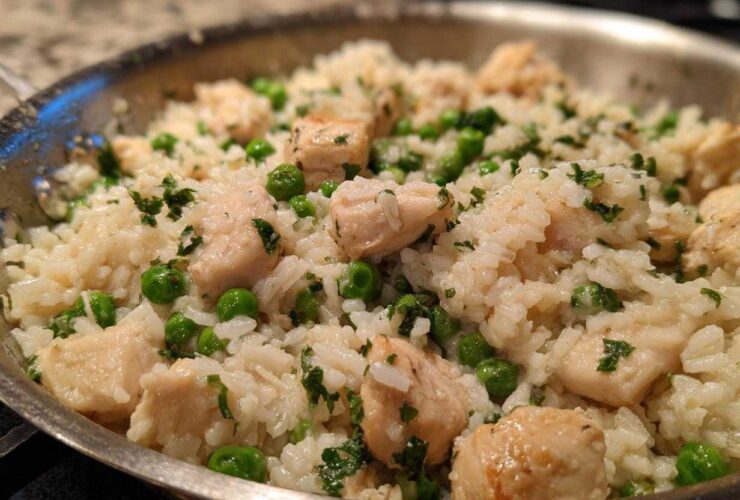 Close-up of Garlic Butter Rice with Chicken Skillet, featuring white rice, cubed chicken, and green peas.