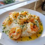 Plated Garlic Butter Shrimp and Rice topped with fresh parsley and rich butter sauce.
