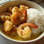 A close-up of a Garlic Butter Shrimp Bowl with Rice, featuring seasoned shrimp in a buttery sauce next to fluffy white rice.